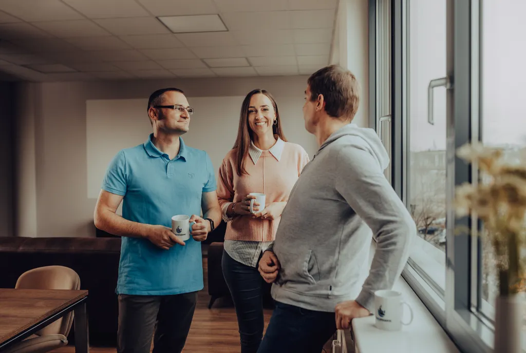 Drei Personen stehen an einem Fenster